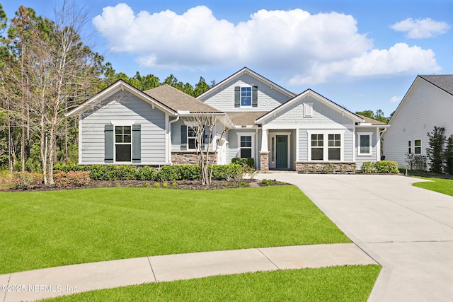 craftsman inspired home featuring stone siding, concrete driveway, and a front yard