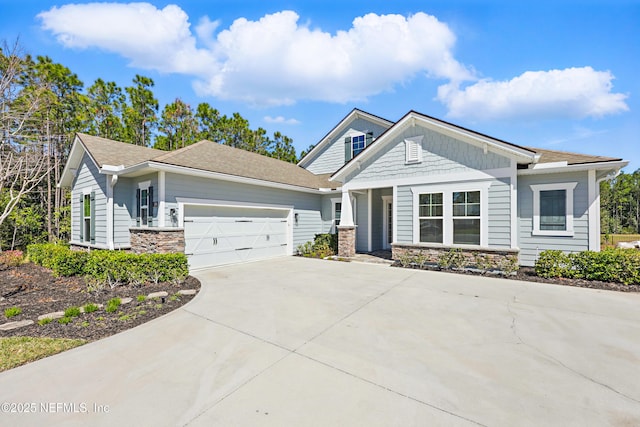 view of front of property with concrete driveway, an attached garage, and stone siding