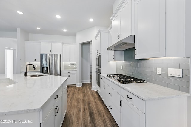 kitchen with under cabinet range hood, a sink, dark wood-style floors, stainless steel appliances, and white cabinets