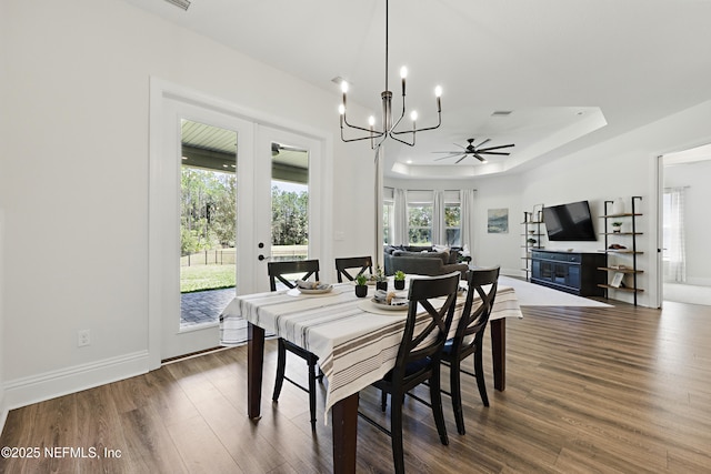 dining room with wood finished floors, french doors, baseboards, a raised ceiling, and ceiling fan