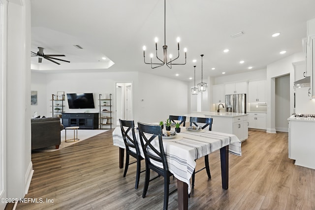 dining room featuring recessed lighting, ceiling fan with notable chandelier, visible vents, and light wood finished floors