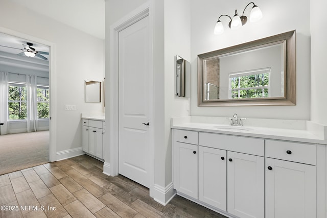 full bathroom with vanity, wood finished floors, baseboards, and a ceiling fan