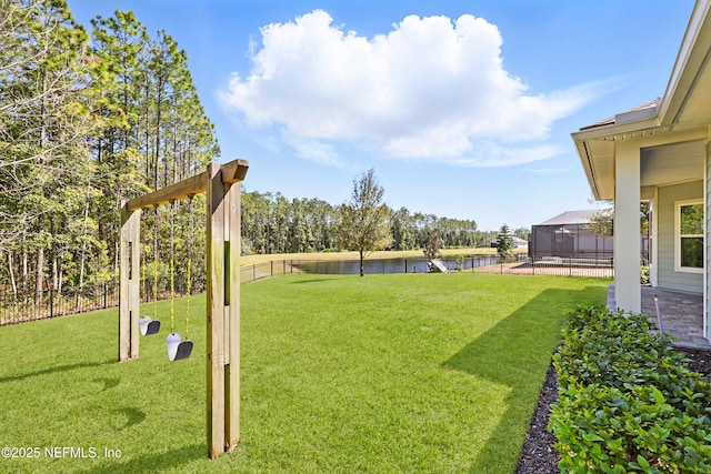 view of yard with a lanai, a fenced backyard, and a water view