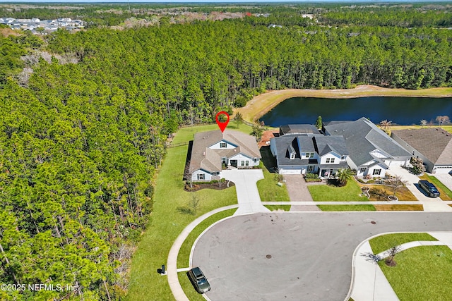 bird's eye view featuring a wooded view, a water view, and a residential view