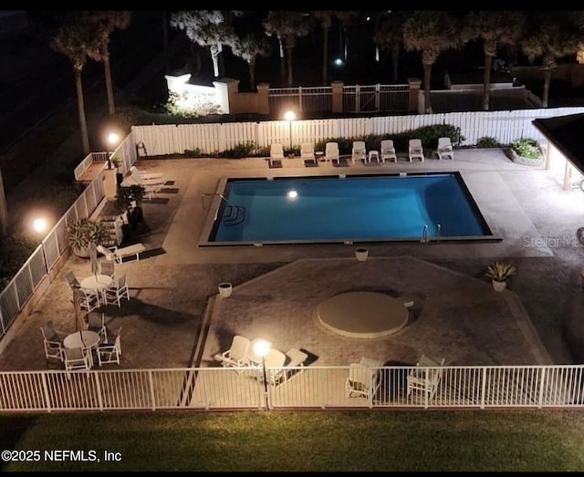 pool with a fenced backyard and a patio