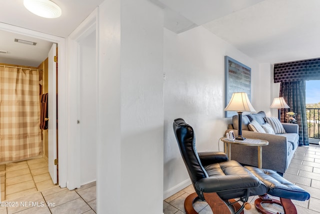 interior space featuring baseboards, visible vents, and light tile patterned flooring