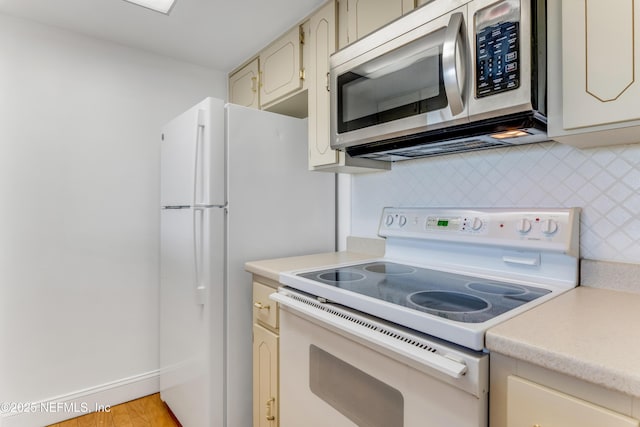 kitchen featuring decorative backsplash, stainless steel microwave, light countertops, and white electric range