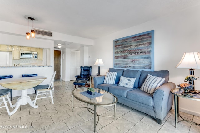 living room featuring visible vents, baseboards, and light tile patterned floors