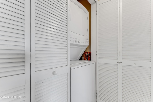 clothes washing area with stacked washer and dryer and laundry area