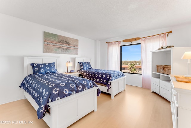 bedroom featuring light wood-type flooring and a textured ceiling