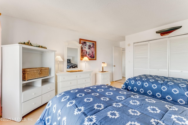 bedroom with a textured ceiling and a closet