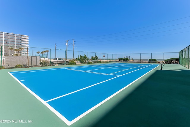 view of tennis court featuring fence