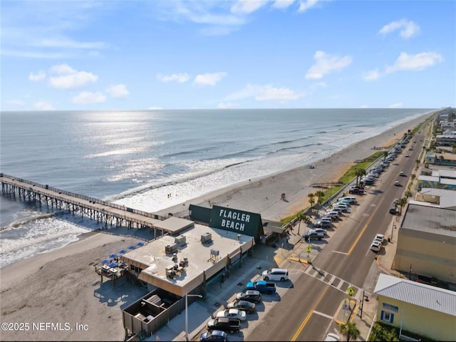 drone / aerial view featuring a water view and a beach view