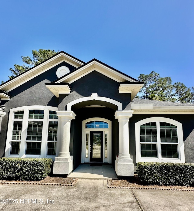 property entrance with stucco siding