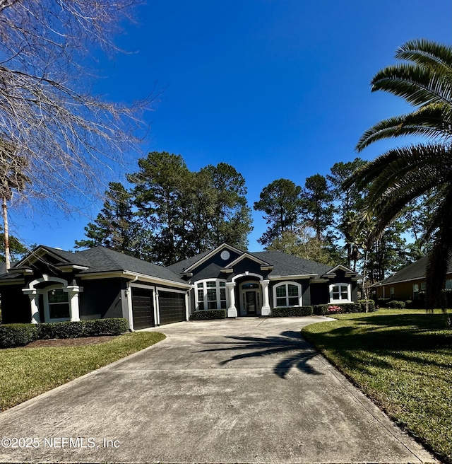 view of front of property with driveway, an attached garage, and a front yard