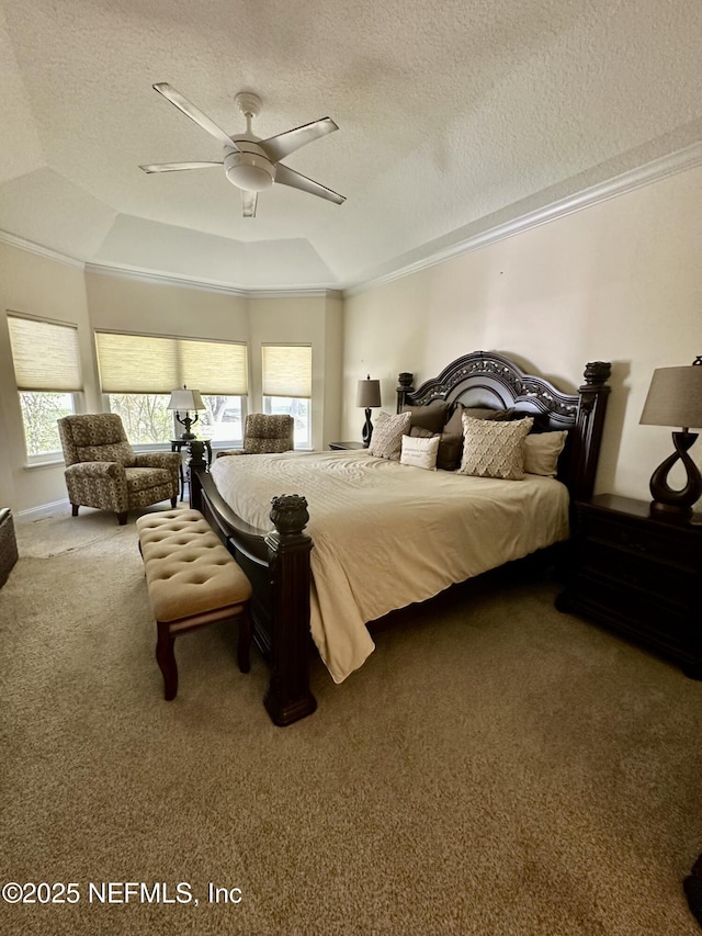 bedroom featuring a raised ceiling, ceiling fan, a textured ceiling, crown molding, and carpet floors