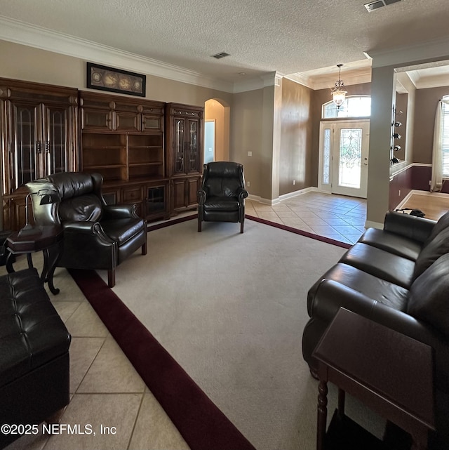 living room featuring arched walkways, light tile patterned flooring, and visible vents