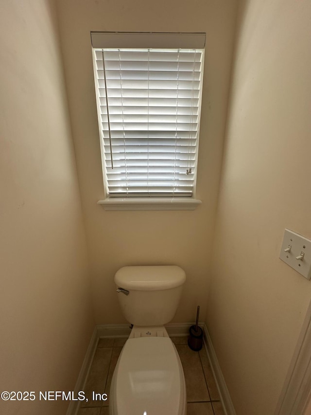 bathroom featuring baseboards, toilet, and tile patterned floors