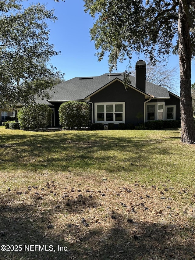 view of front of property featuring a front lawn and a chimney