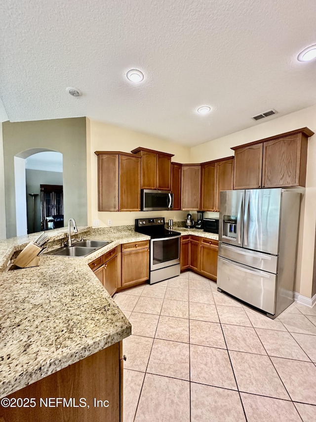 kitchen with light tile patterned floors, visible vents, appliances with stainless steel finishes, a sink, and a textured ceiling