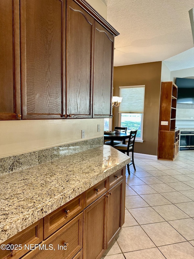 kitchen featuring a textured ceiling, light tile patterned floors, and baseboards