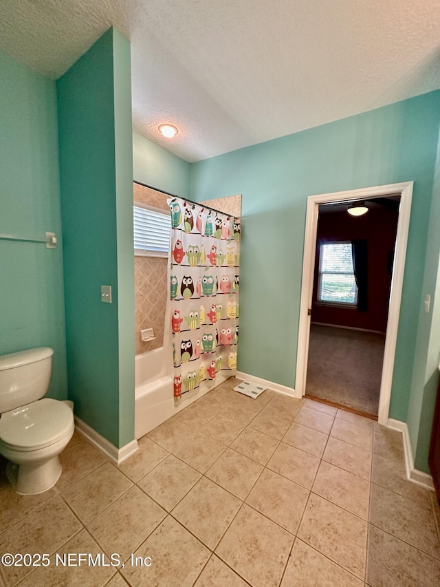 full bath with a textured ceiling, tile patterned flooring, toilet, and baseboards