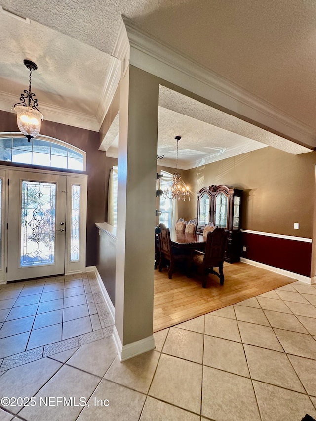 entrance foyer featuring a wealth of natural light, tile patterned flooring, and a notable chandelier