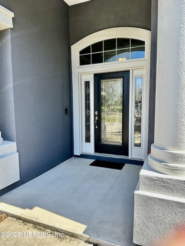 property entrance with stucco siding