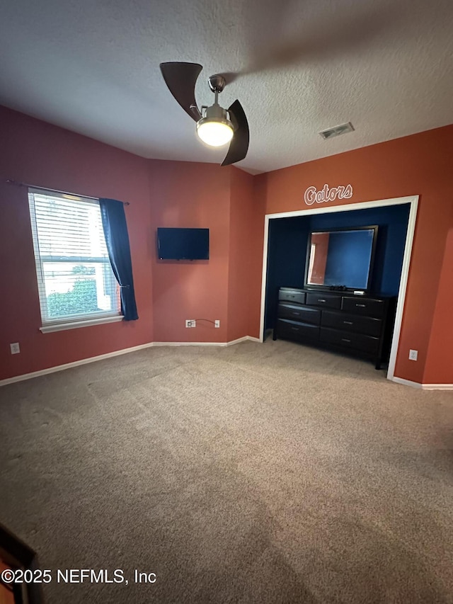 home theater room with light carpet, baseboards, visible vents, and a textured ceiling