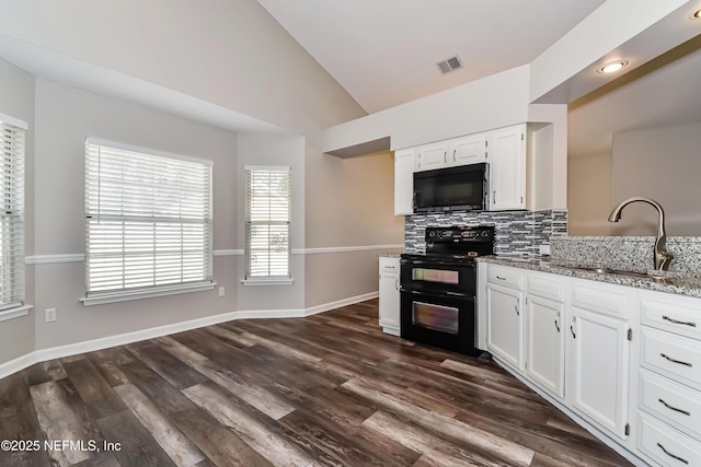 kitchen with light stone counters, visible vents, vaulted ceiling, a sink, and black appliances