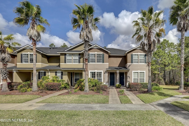 view of front of house with a front lawn and stucco siding