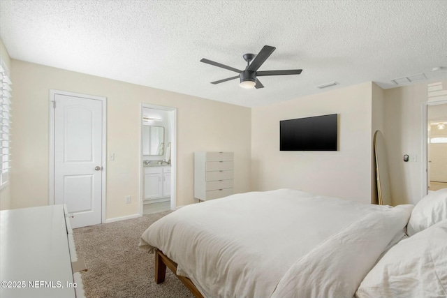 bedroom with carpet flooring, connected bathroom, visible vents, and a textured ceiling