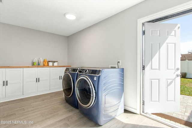 washroom with laundry area, separate washer and dryer, and light wood finished floors