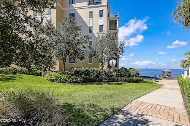 surrounding community featuring a yard, a boat dock, and a water view