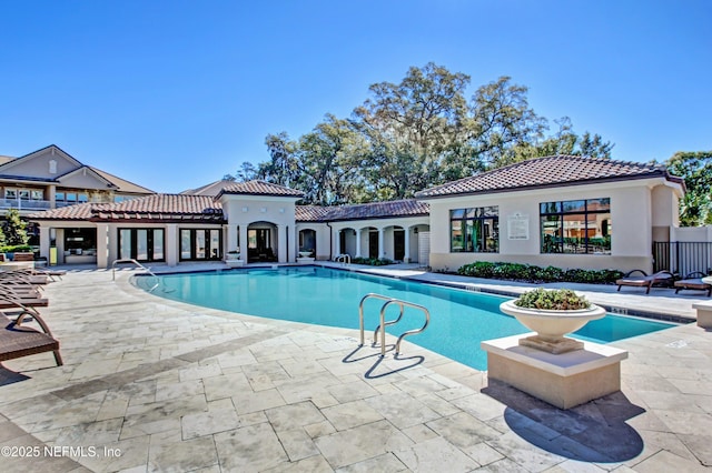 community pool featuring french doors and a patio