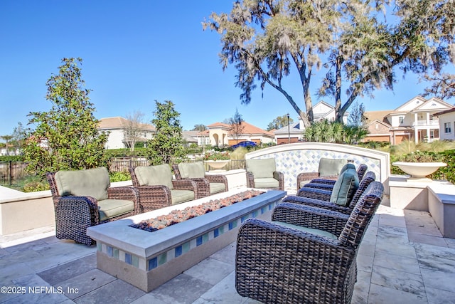 view of patio with a residential view, fence, and a fire pit