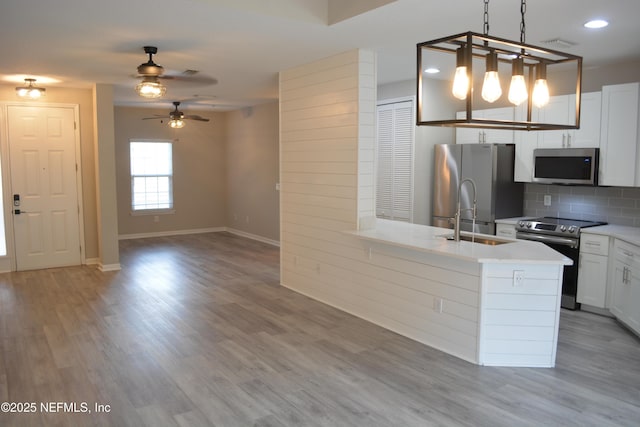 kitchen featuring visible vents, stainless steel appliances, light wood-style flooring, and decorative backsplash