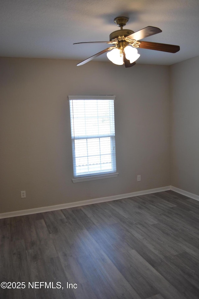 unfurnished room featuring dark wood-type flooring and baseboards