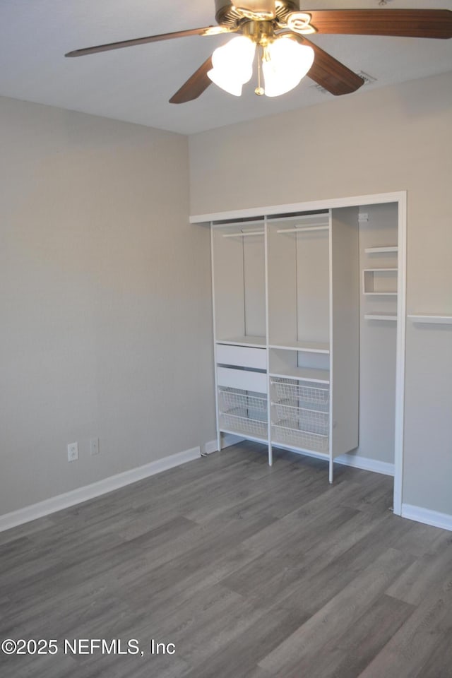 unfurnished bedroom with ceiling fan, a closet, baseboards, and wood finished floors