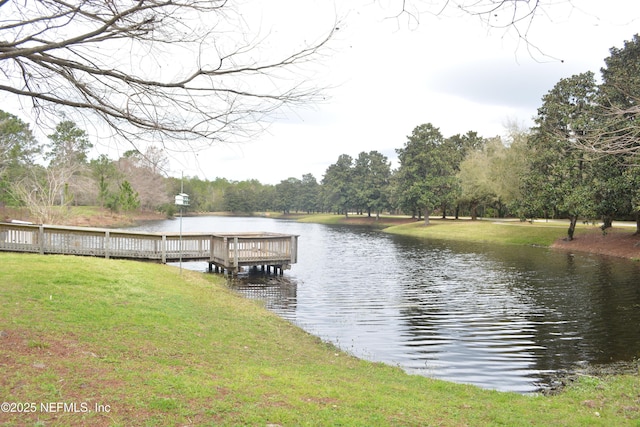 view of dock with a water view and a yard