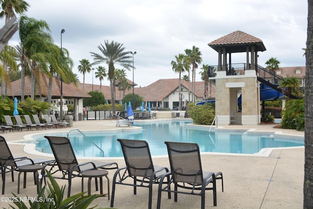 community pool with a gazebo, a patio area, and fence