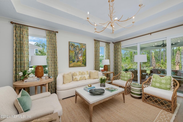 living area with a tray ceiling and a notable chandelier