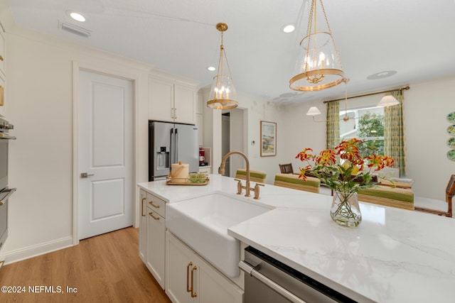 kitchen featuring visible vents, appliances with stainless steel finishes, light wood-type flooring, white cabinetry, and a sink