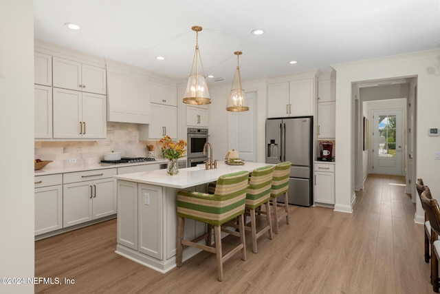 kitchen with tasteful backsplash, light wood-style flooring, stainless steel appliances, and light countertops