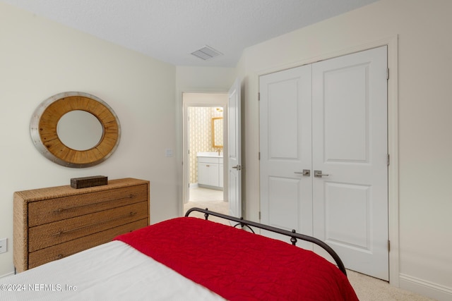 carpeted bedroom with a textured ceiling, a closet, and visible vents