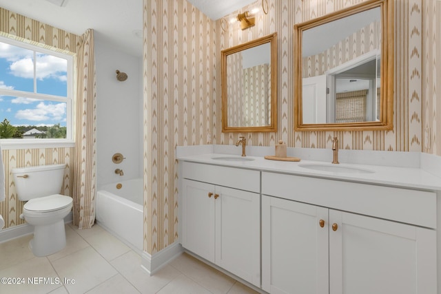 bathroom featuring toilet, wallpapered walls, and a sink