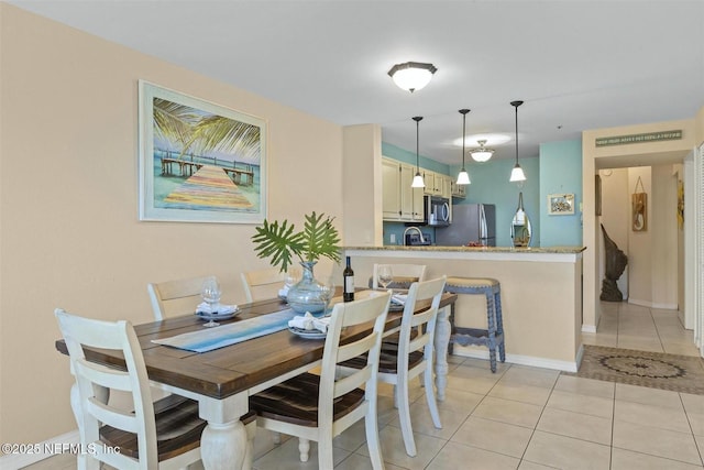 dining space featuring baseboards and light tile patterned floors