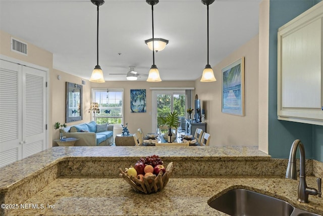110 Ocean Hollow Ln Unit 116, Saint Augustine, FL 32084 - kitchen featuring visible vents, a sink, decorative light fixtures, and light stone countertops