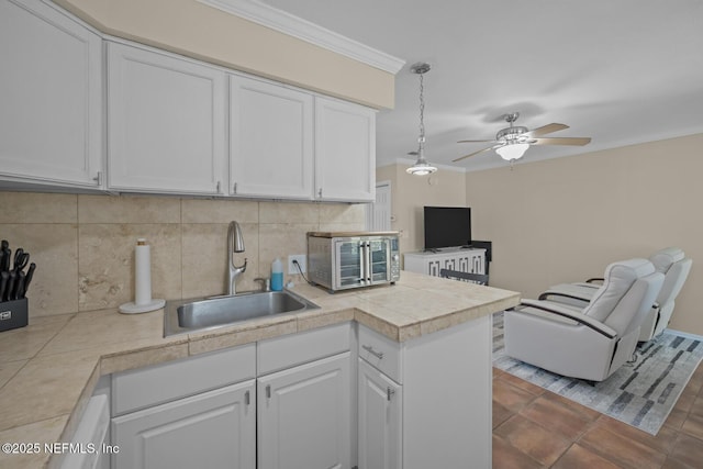 2107 2nd St S, Jacksonville Beach, FL 32250 - kitchen with decorative backsplash, white cabinets, a ceiling fan, and a sink