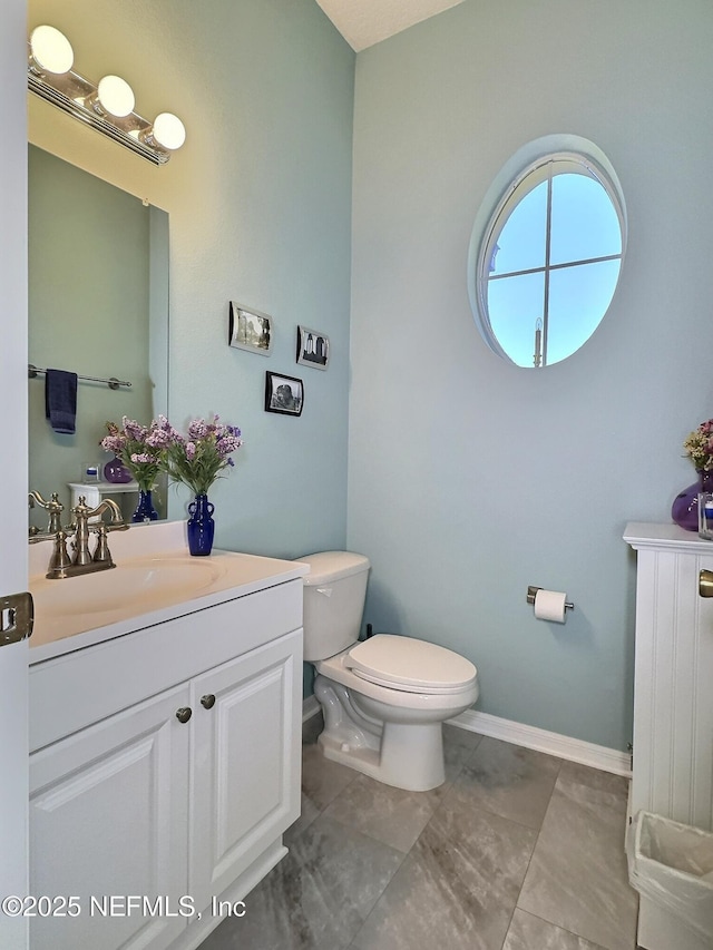 bathroom with vanity, toilet, and baseboards